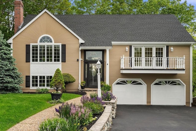 4 Blacksmith Way, Saugus, MA 01906 - view of front facade with a balcony, asphalt driveway, an attached garage, a chimney, and a front lawn
