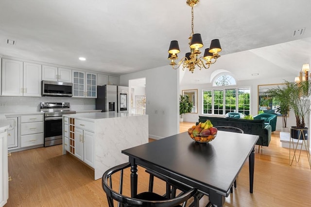4 Blacksmith Way, Saugus, MA 01906 - kitchen featuring appliances with stainless steel finishes, a chandelier, light countertops, a center island, and glass insert cabinets