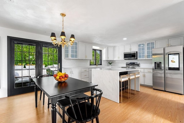 4 Blacksmith Way, Saugus, MA 01906 - kitchen with appliances with stainless steel finishes, a chandelier, light countertops, a kitchen island, and light wood-style flooring