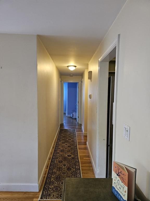 hall with wood finished floors and baseboards