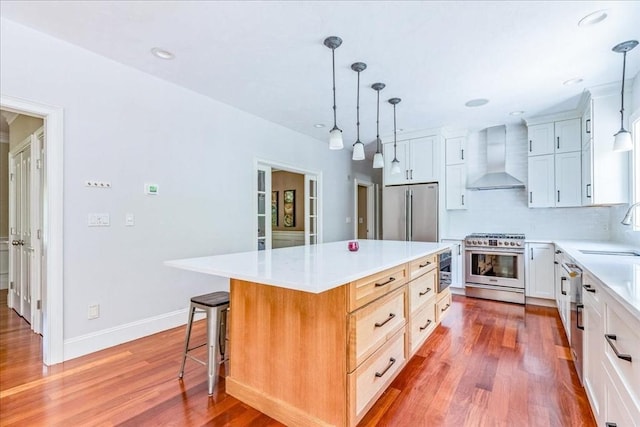 138 Saddleworth Way, Middleboro, MA 02346 - kitchen with stainless steel appliances, wall chimney exhaust hood, wood finished floors, light countertops, and a center island