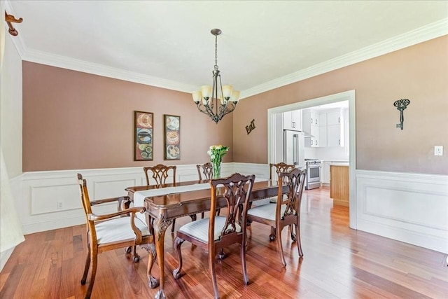 138 Saddleworth Way, Middleboro, MA 02346 - dining space featuring a chandelier, light wood-style flooring, a wainscoted wall, and crown molding
