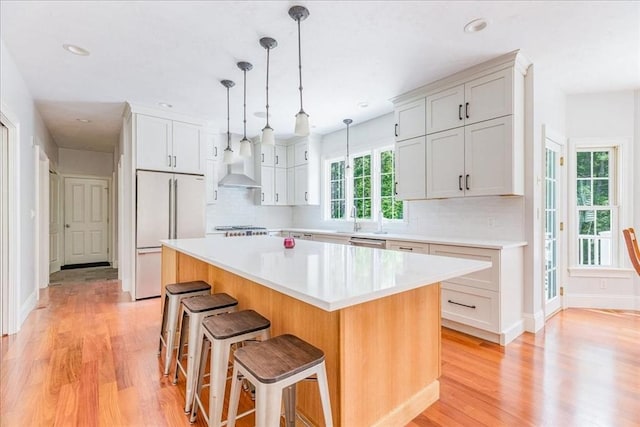 138 Saddleworth Way, Middleboro, MA 02346 - kitchen with high end fridge, light wood-type flooring, decorative backsplash, a breakfast bar area, and recessed lighting