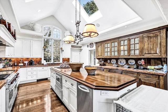 141 Daniels Island Rd, Mashpee, MA 02649 - kitchen featuring appliances with stainless steel finishes, wood counters, a center island, a skylight, and glass insert cabinets