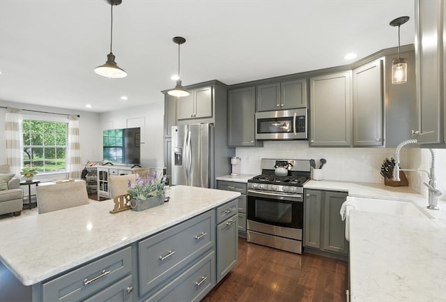 22 Dean St, Hudson, MA 01749 - kitchen with stainless steel appliances, gray cabinetry, open floor plan, light stone counters, and backsplash