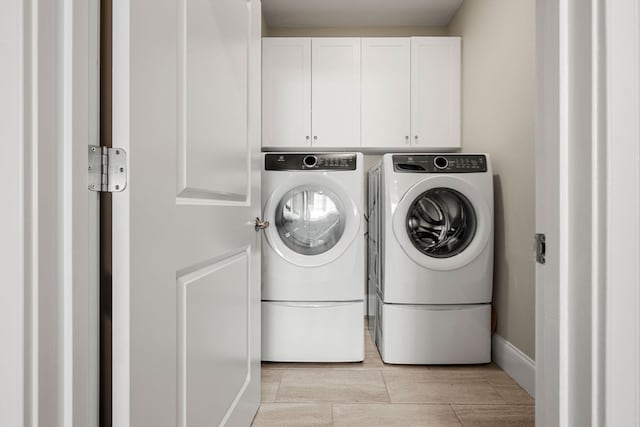 washroom with washing machine and dryer and cabinets