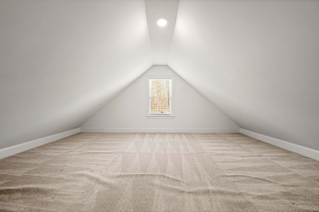 bonus room featuring lofted ceiling and light colored carpet