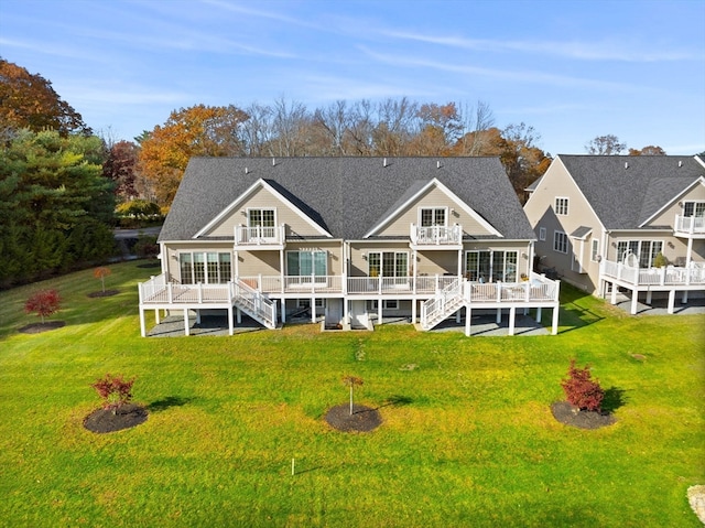 rear view of property featuring a wooden deck, a lawn, and a sunroom