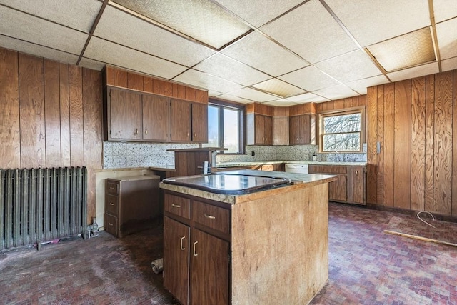 33 Burbank St, Millbury, MA 01527 - kitchen with radiator heating unit, plenty of natural light, wood walls, a paneled ceiling, and a kitchen island