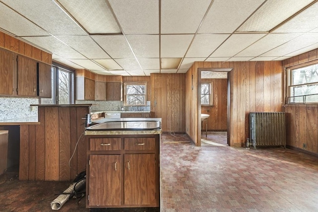33 Burbank St, Millbury, MA 01527 - kitchen with radiator, wooden walls, a peninsula, a paneled ceiling, and brown cabinetry
