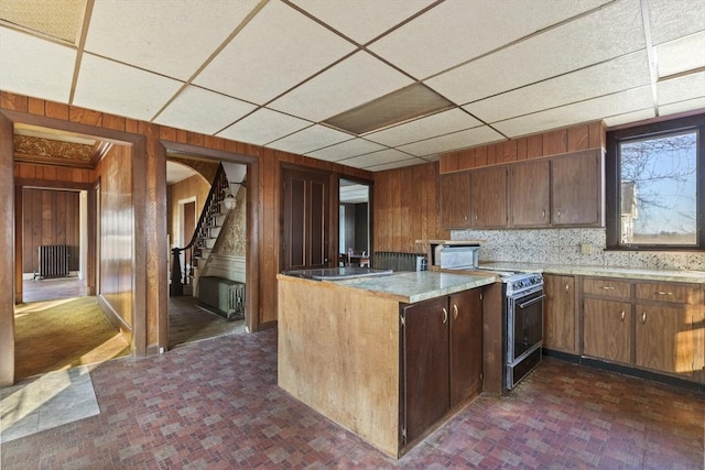 33 Burbank St, Millbury, MA 01527 - kitchen with electric range, wooden walls, a paneled ceiling, a peninsula, and light countertops
