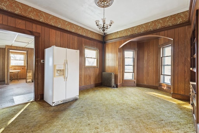 33 Burbank St, Millbury, MA 01527 - carpeted empty room with radiator heating unit, healthy amount of natural light, arched walkways, a chandelier, and crown molding