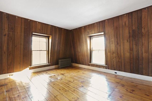 33 Burbank St, Millbury, MA 01527 - spare room with radiator, light wood-style floors, and wooden walls