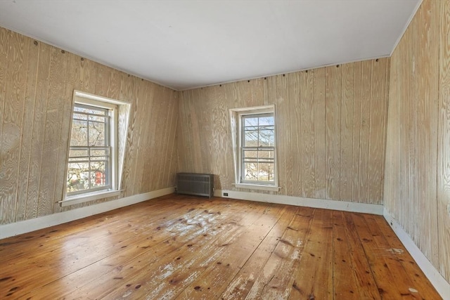 33 Burbank St, Millbury, MA 01527 - unfurnished room with radiator, hardwood / wood-style flooring, baseboards, and wood walls