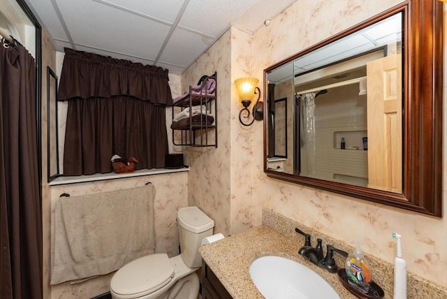 bathroom with a paneled ceiling, vanity, and toilet