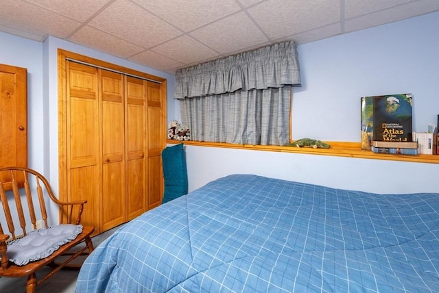 bedroom with a paneled ceiling and a closet