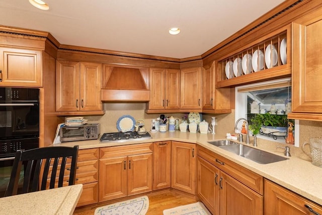 kitchen with double oven, sink, custom range hood, and stainless steel gas cooktop