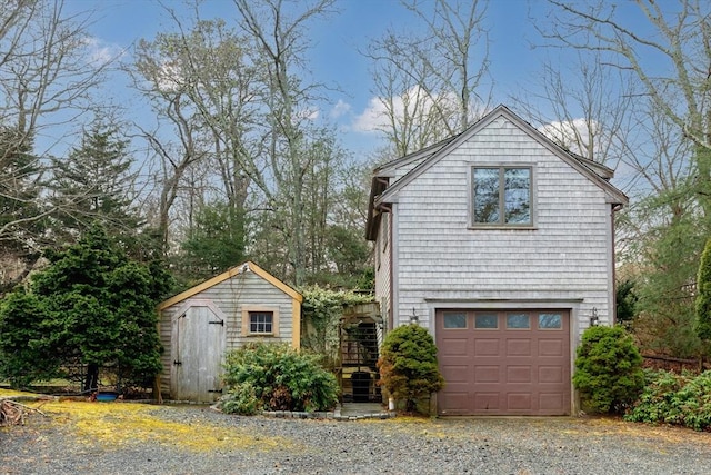 exterior space with an outbuilding, an attached garage, stairway, and a storage shed