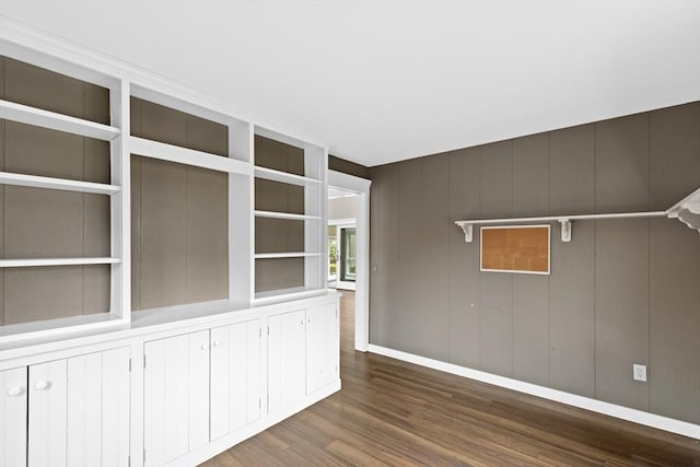 unfurnished room with built in features and dark wood-style flooring