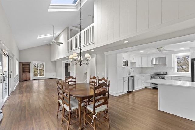 dining space with a skylight, ceiling fan with notable chandelier, and a healthy amount of sunlight