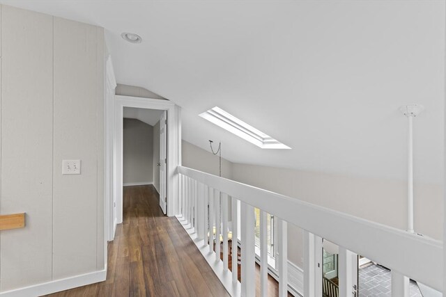 hall with wood finished floors and lofted ceiling with skylight
