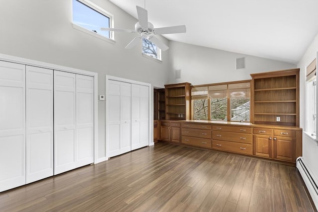 interior space featuring a baseboard heating unit, dark wood-style flooring, multiple closets, ceiling fan, and visible vents