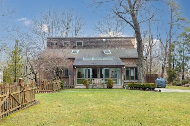 view of front facade with a sunroom, fence, and a front yard