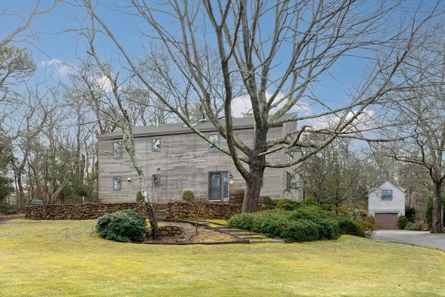 view of side of property with an outbuilding and a lawn