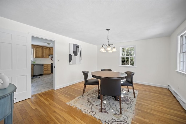 dining room featuring a baseboard heating unit, baseboards, a notable chandelier, and light wood-style floors