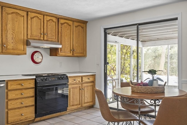 kitchen featuring brown cabinets, under cabinet range hood, black range with electric cooktop, and light countertops