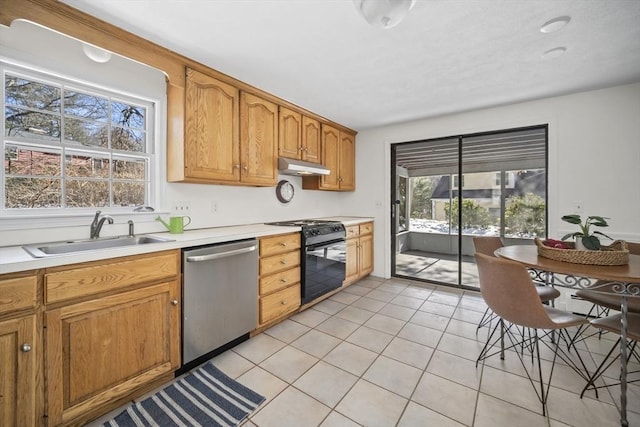 kitchen with light tile patterned floors, dishwasher, black gas range oven, under cabinet range hood, and a sink