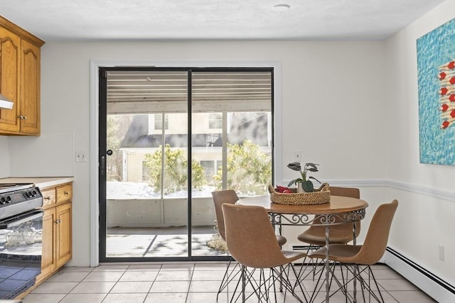 dining room featuring a healthy amount of sunlight, light tile patterned floors, and a baseboard radiator