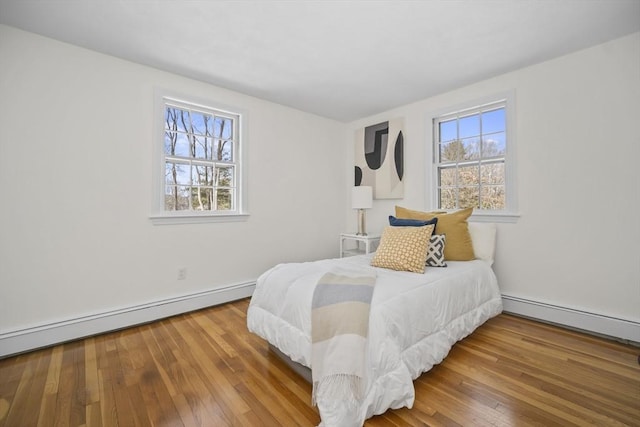 bedroom with wood-type flooring and baseboard heating