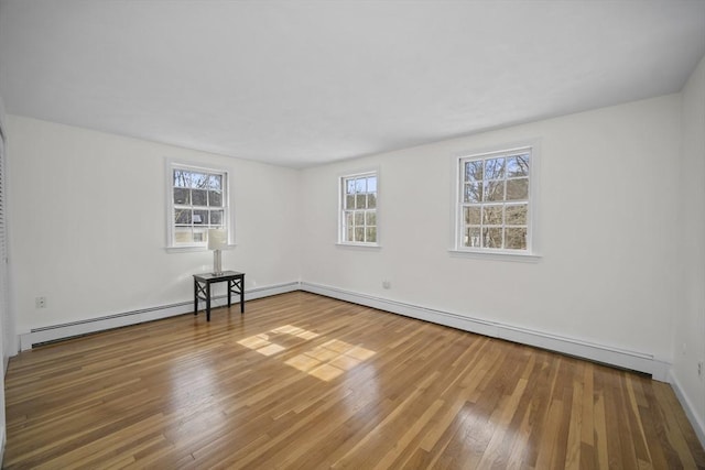 unfurnished room with plenty of natural light and wood finished floors