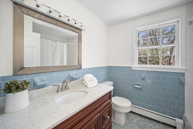 bathroom featuring tile walls, toilet, a baseboard heating unit, wainscoting, and vanity