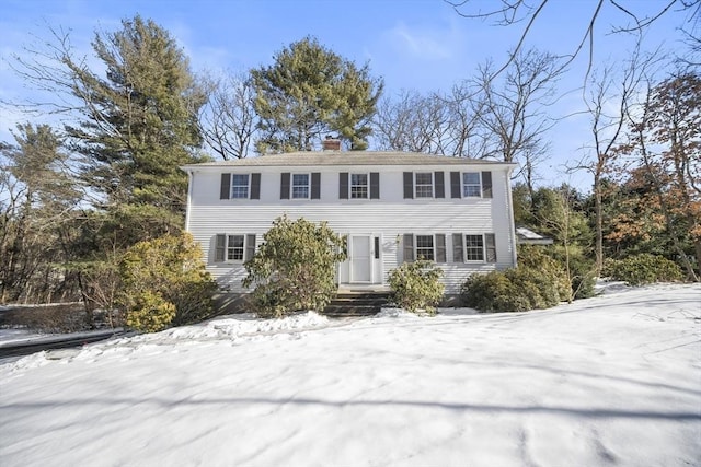 colonial-style house featuring a chimney