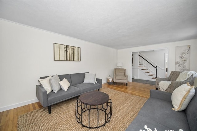 living room with stairway, baseboards, and wood finished floors