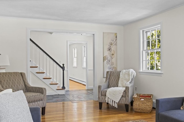 entryway featuring a baseboard radiator, stairs, ornamental molding, and wood finished floors