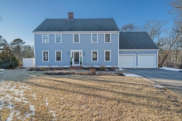 colonial house with a garage and a front lawn