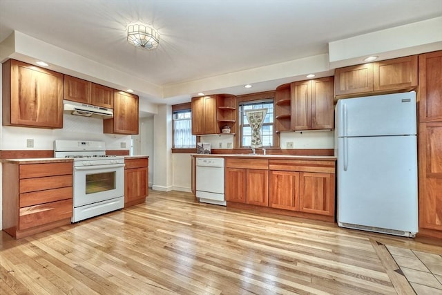 kitchen with brown cabinets, light wood finished floors, open shelves, white appliances, and under cabinet range hood