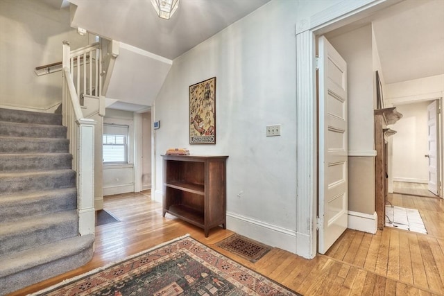 interior space featuring stairway, baseboards, visible vents, and hardwood / wood-style floors