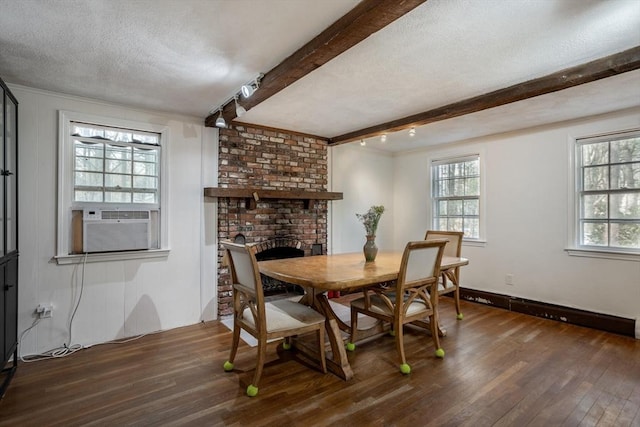 dining area with a wealth of natural light, a textured ceiling, beam ceiling, and wood finished floors