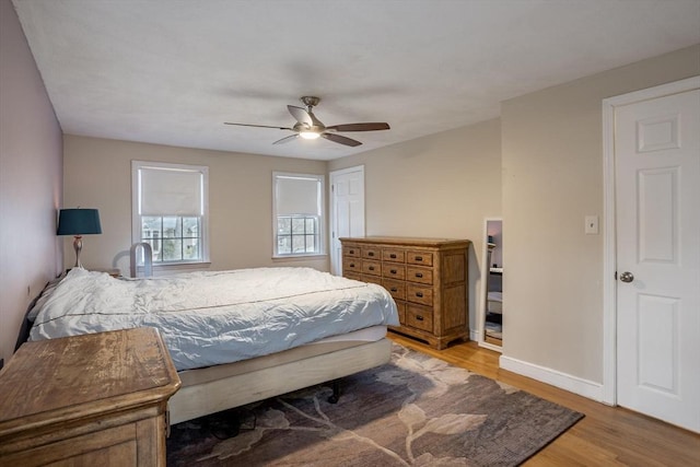 bedroom featuring a ceiling fan, light wood-style flooring, and baseboards