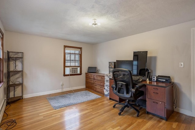 office featuring a textured ceiling, cooling unit, baseboards, light wood-style floors, and baseboard heating