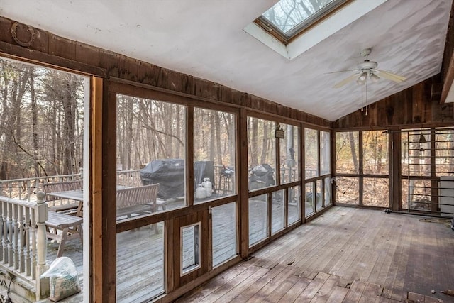 unfurnished sunroom featuring ceiling fan and lofted ceiling with skylight