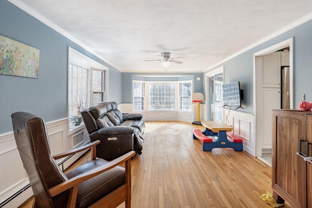 interior space featuring a wainscoted wall, light wood-style flooring, and a baseboard heating unit