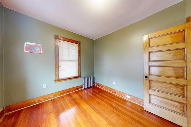 76 Belden St, Boston, MA 02125 - spare room featuring radiator, wood finished floors, and baseboards