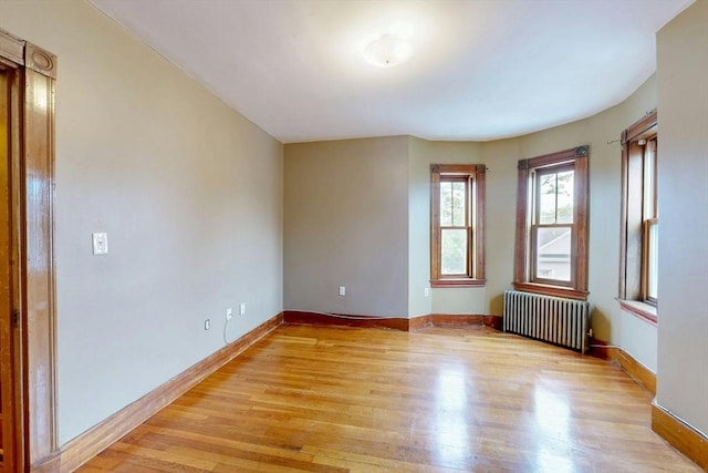 76 Belden St, Boston, MA 02125 - empty room featuring radiator, light wood-type flooring, and baseboards