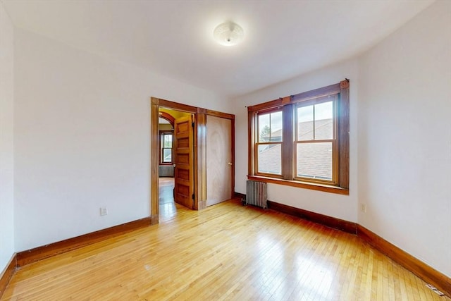 76 Belden St, Boston, MA 02125 - spare room featuring radiator heating unit, baseboards, and light wood-style flooring