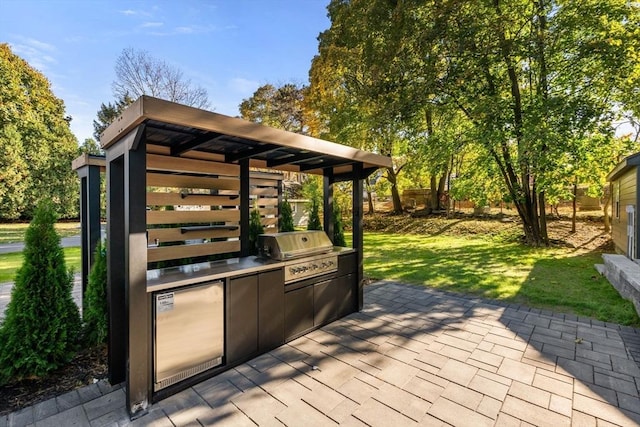 wooden deck with grilling area, a yard, and an outdoor kitchen